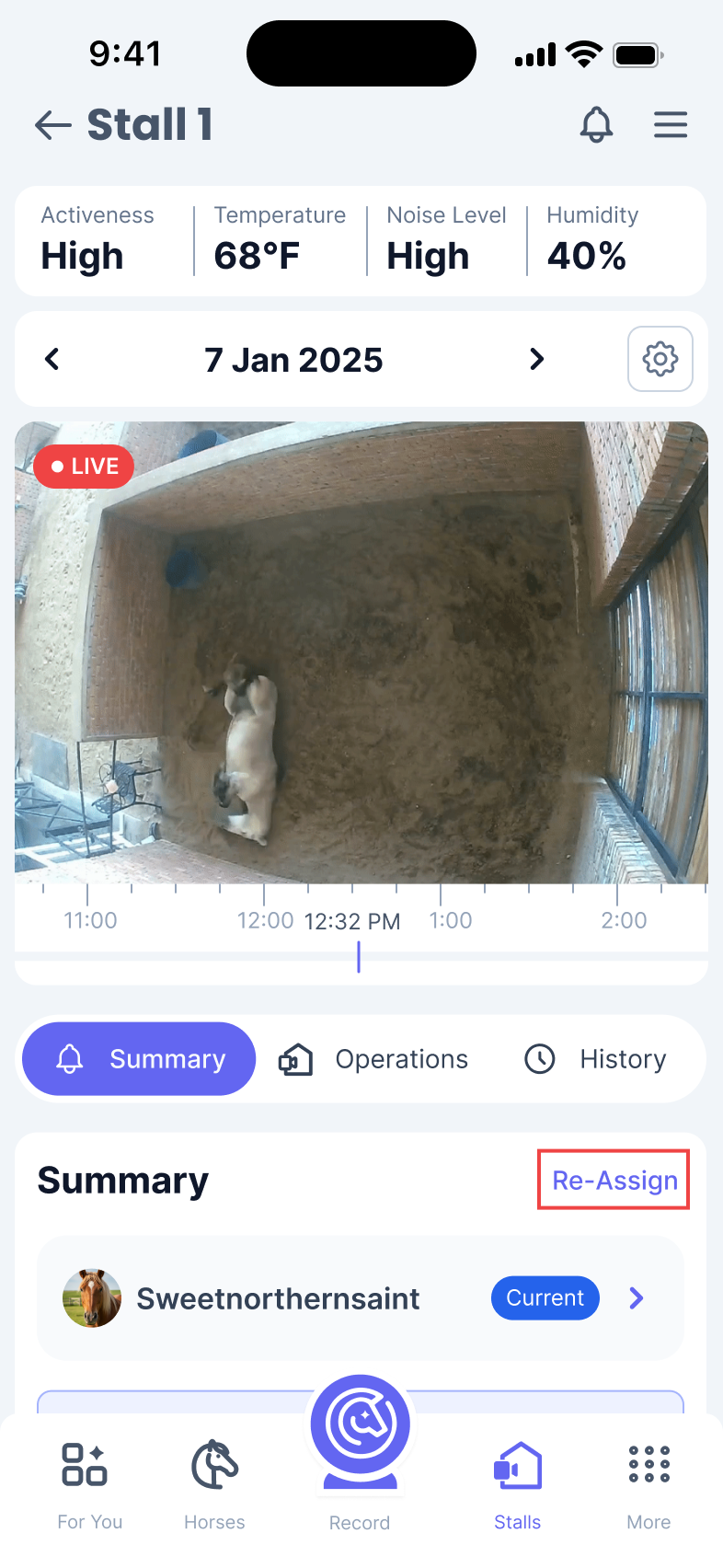 Phone screen of a page titled Stall 1. The video feed on the page shows a horse rolling and a button called ‘Re-Assign’ is highlighted.