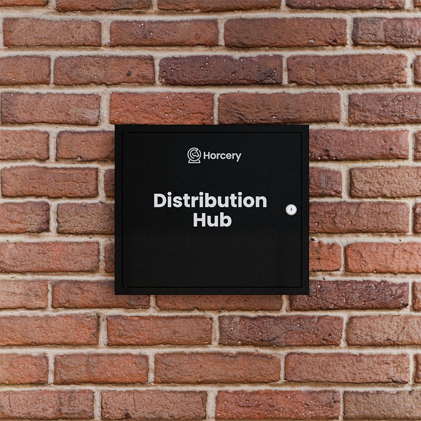 A black Horcery Distribution Hub mounted on a red brick wall, featuring the Horcery logo and bold white text identifying the device.